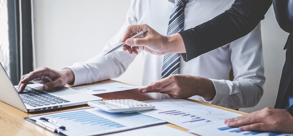 People reviewing financial reports as part of year-end tax planning.