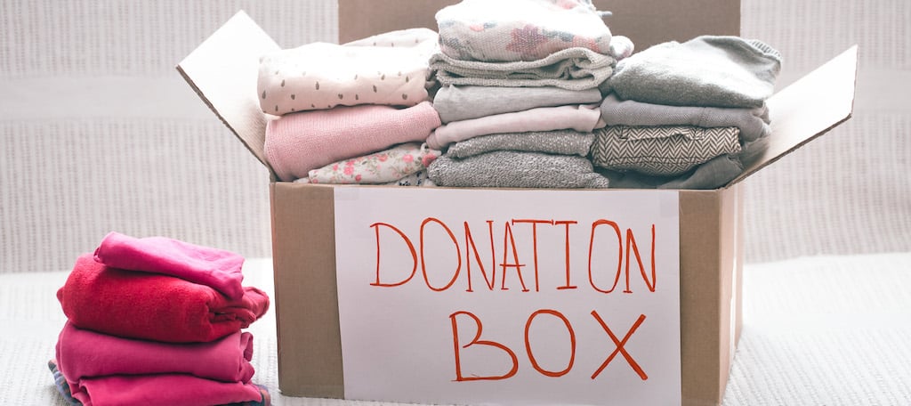 donation box with clothes, representing charitable donations as part of year-end tax planning.