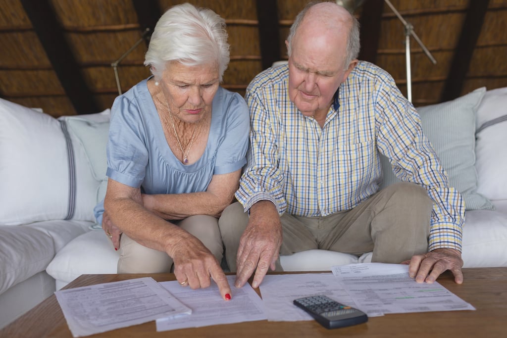 elderly couple reviewing tax returns while doing year-end tax planning.