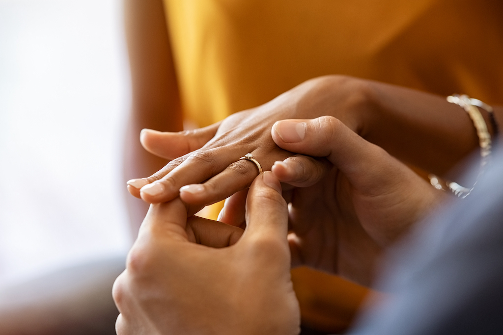 person fiddling with wedding ring, representing adjustments in marital status as part of year-end tax planning.