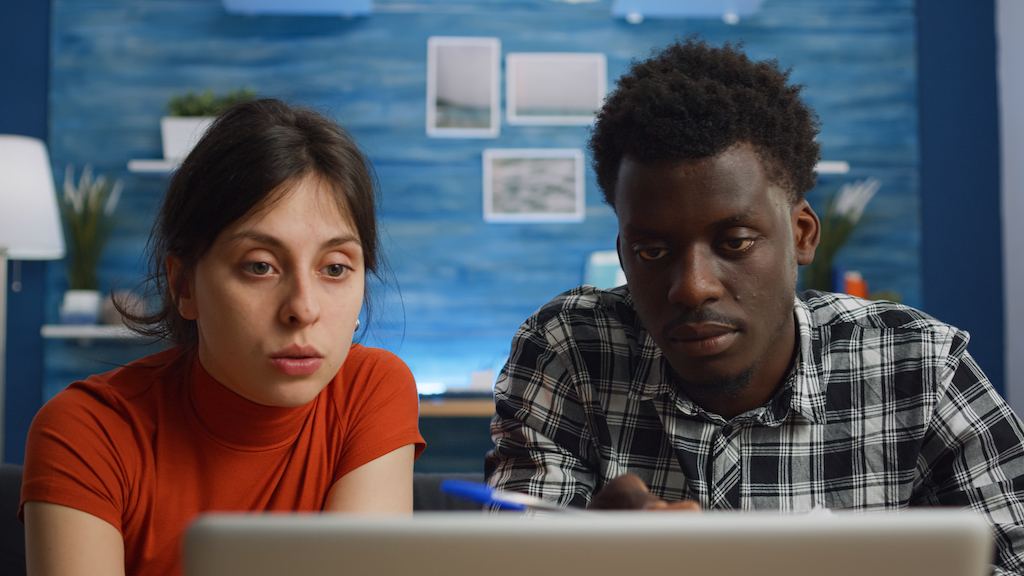 couple looking at laptop while doing year-end tax planning.