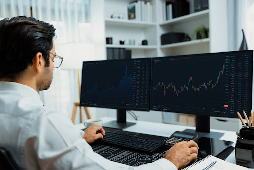 Smart trader businessman analyzing in two dynamic stock exchange investment screen on pc with investing highest profitable financial technology in searching market at modern home office. Surmise.